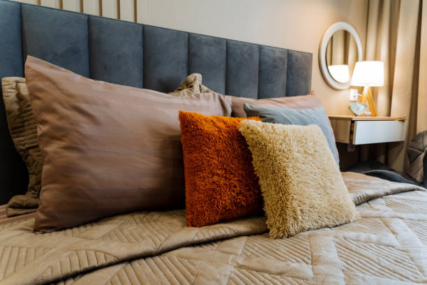 istock In a wonderfully cozy and inviting bedroom, there is a beautifully made bed that is adorned with numerous fluffy and soft pillows, creating a perfect atmosphere for resting and relaxation 2201519178