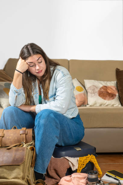 istock Impossible luggage, girl sitting on her too-small suitcase 2201524301