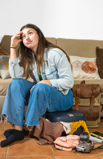 istock Small suitcase, girl sitting in it thoughtfully 2201524434