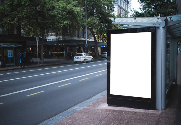 istock Blank white mock up of vertical light box in a bus stop at night 2201525095