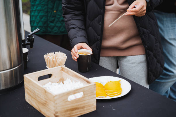 A woman is gently cradling a steaming cup of rich, aromatic coffee on an elegantly arranged table, savoring a peaceful and serene moment in a cozy, warm, and inviting setting