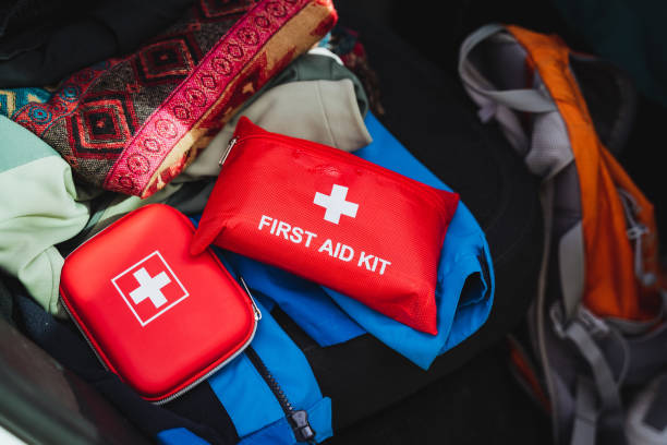 istock A bright red first aid kit is prominently positioned on top of a vibrant blue backpack, creating a striking contrast in colors that draws the eye immediately to their arrangement 2201525616