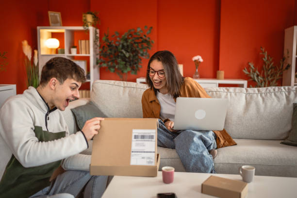 istock Two friends boyfriend and girlfriend enthusiastically open the package 2201532633
