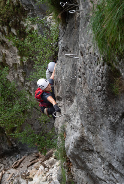 istock A female climber reaches for a step while she climbs a steep wall on a via ferrata. 2201533937