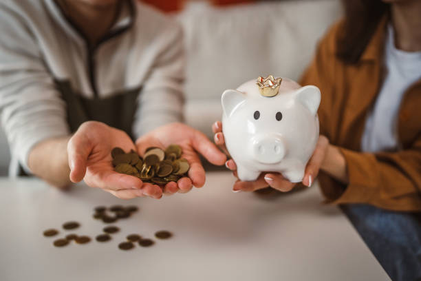 istock close up on piggy bank with coins on white table 2201534202