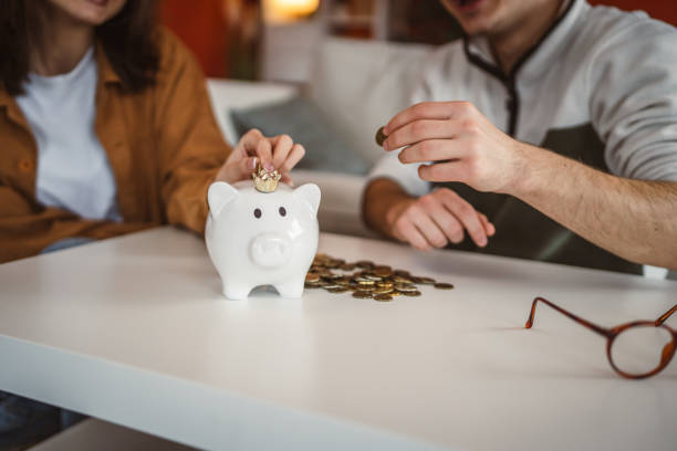 istock close up on piggy bank with coins on white table 2201534322
