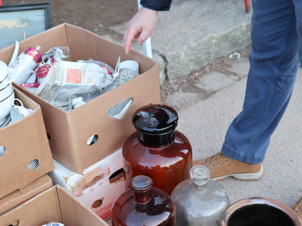 istock man looking at dishes in cardboard boxes at a garage sale 2201534485