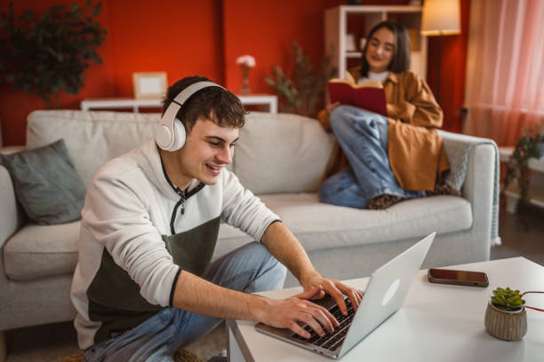 istock man work from home on laptop while woman read a book on sofa 2201534541