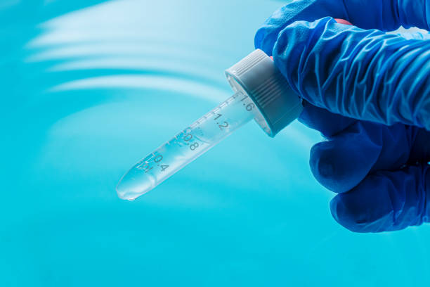 istock Close-up science experiments,Close up view macro shot of gel with different sized bubbles comes out from lab dropper into petri dish on blue background | Abstract face care gel with hyaluronic acid mixing concept 2201541368