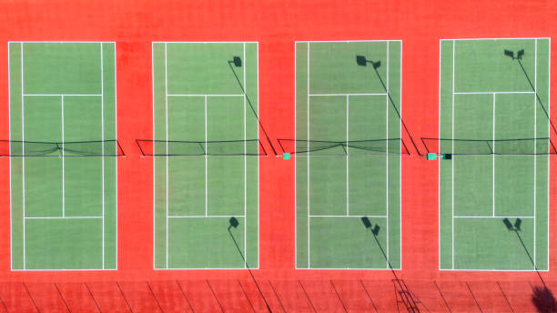 Drone overhead view of tennis courts with a synthetic surface in different colours. No people. Sport concept.