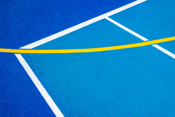 Sport field court background. Blue rubberized and granulated ground surface with white, yellow lines on ground. Top view.