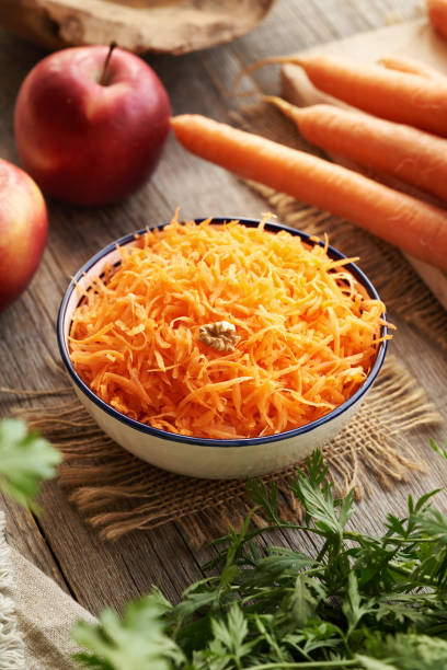 istock Fresh carrot salad on a wooden table with red apples 2201551242