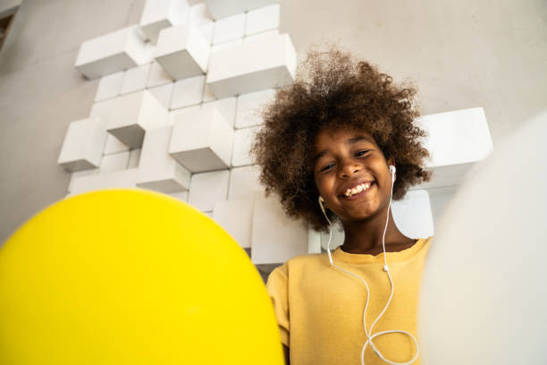 istock Little Girl Smiling and Dancing with Balloons Inside 2201555296