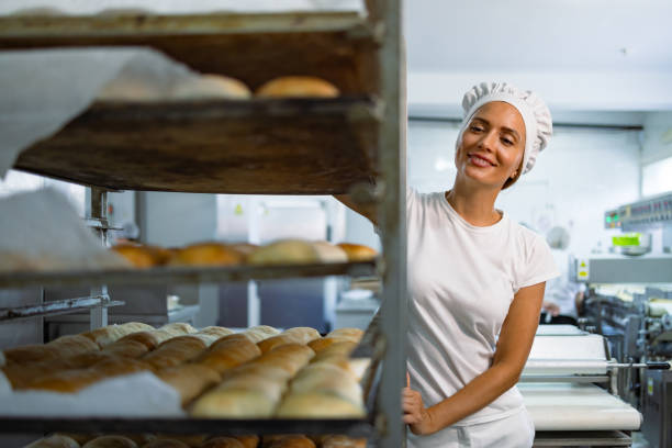 istock Baker pushing a rack of freshly baked bread in a bakery 2201565958