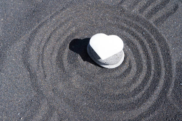 istock balancing stone with flower of life on black sand background 2201568524