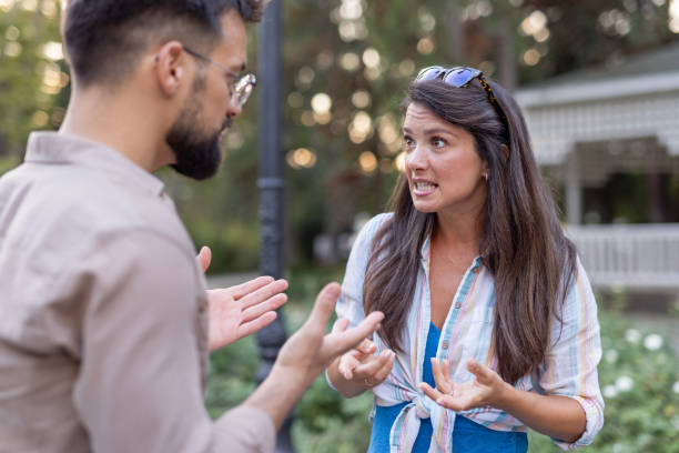 istock Animated discussion unfolds between man and woman in park. 2201571620