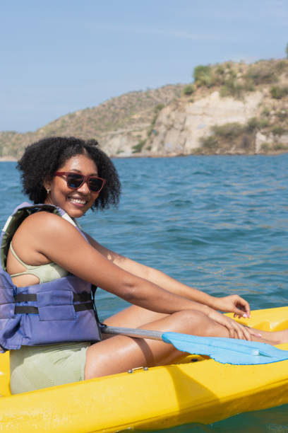 istock Young woman kayaking in a lake with mountain view 2201572160