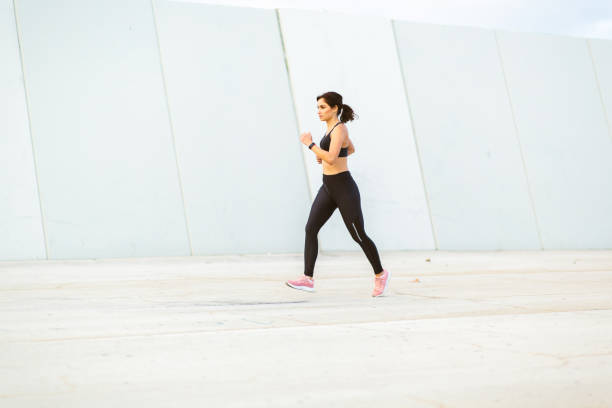 istock Healthy young woman running outdoors in morning 2201572284
