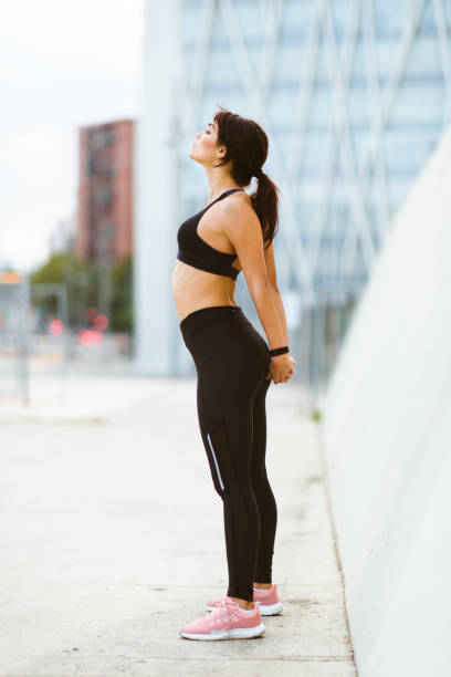 istock Fitness woman standing outside and doing stretching workout 2201572308