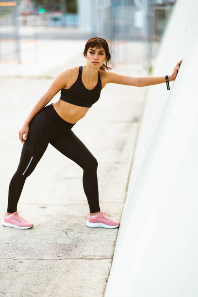 istock Healthy young woman standing by a wall outside 2201572309
