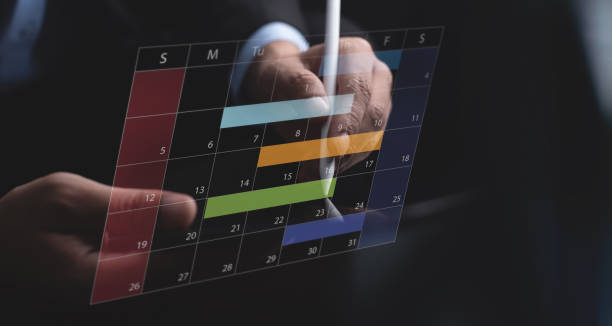 Business event planning, calendar agenda work schedule concept. Businessman using digital tablet with monthly calendar planner, workflow plan, and organize schedules. Work time management