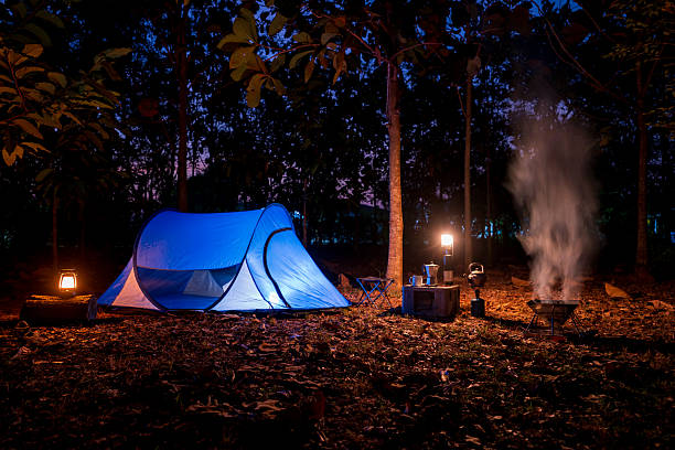Camping tent in the forest, falling leaves in winter with outdoor coffee-making facilities in a forest camping area