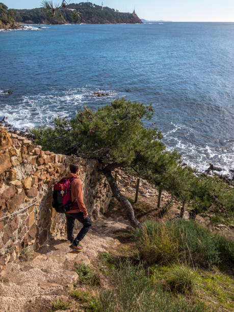 istock Young man hikes down pathway to sea 2201577047