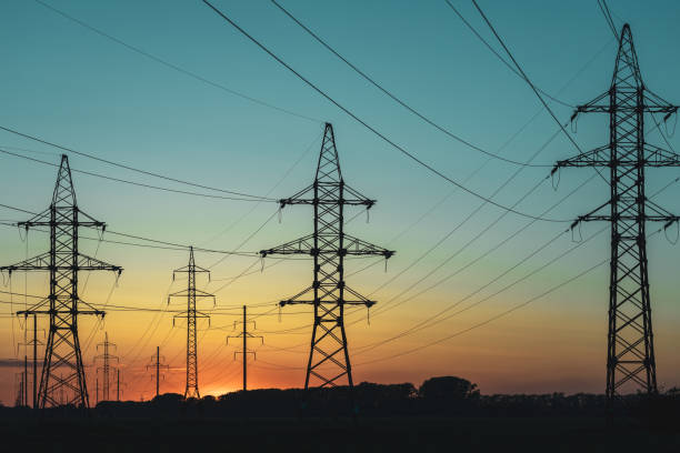 istock A group of power lines are silhouetted against a beautiful sunset 2201593430