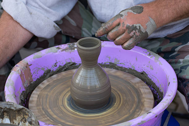 Hands of a potter, creating an earthen jar on the circle., In Bistrita, Romania 2024