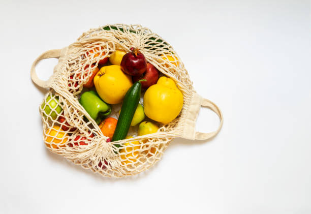 istock White string bag with different vegetables and fruits on a white background. top view. 2201593951
