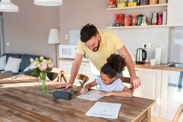 istock Focused Caucasian Father Helping Mixed Race Daughter with Homework 2201595791