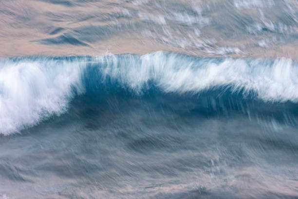 A long exposure Photograph of a wave in motion creating a blurred abstract image.