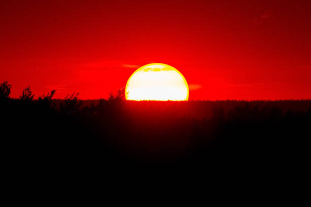 istock Spectacular sunset with big round sun and red sky. 2201597671