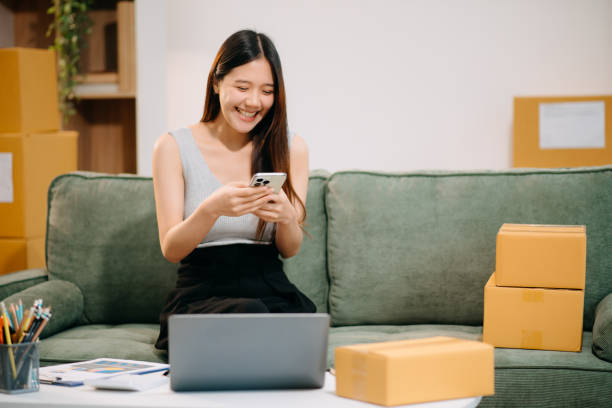 istock Woman Entrepreneur: SME Business mastering e-commerce with tablet, laptop, packaging, with Online Marketing, 2201611615