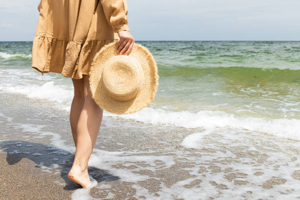 istock A man walks barefoot on the sand on the beach. 2201623940