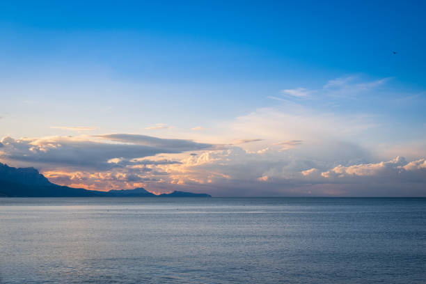 Sunset over the sea. silhouetted mountains on the horizon
