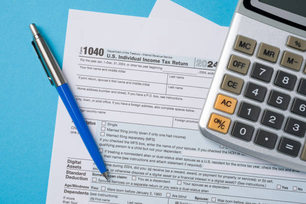 istock Top view of tax forms, calculator and pen on blue table 2201625098