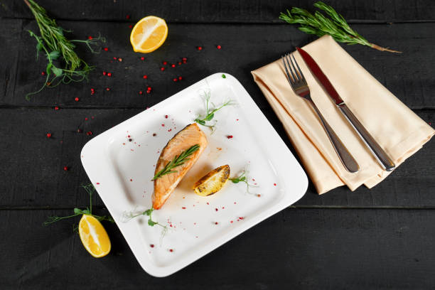 red fish steak with rosemary sauce and lemon restaurant menu on a black background.