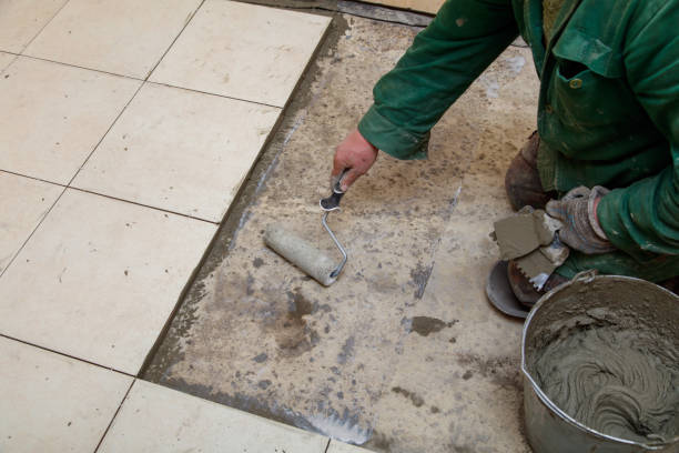 istock A man is laying down on the floor and painting a tile 2201628497