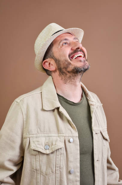 Portrait of a cheerful tourist wearing a hat, looking up with a joyful expression