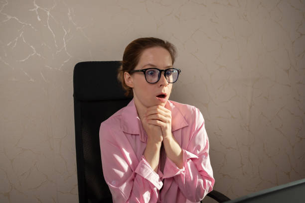 istock Surprised woman in office at laptop, expressing interest in a professional challenge, working on a job task, involved in online communication. 2201631797