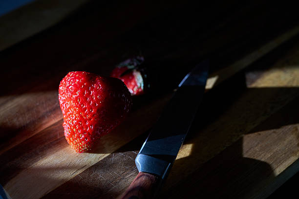 strawberry and knife on cutting board