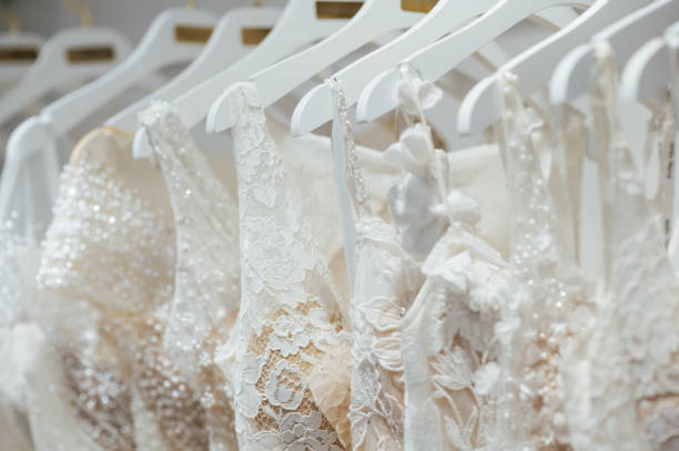 Wedding dresses in store. wedding dresses hang in a row on hangers.