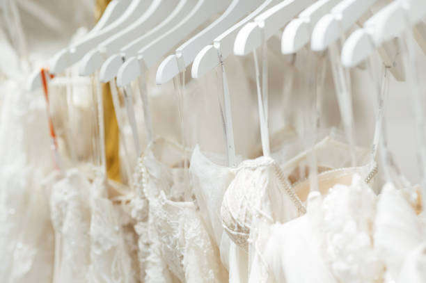 istock Wedding dresses in store. wedding dresses hang in a row on hangers. 2201633518