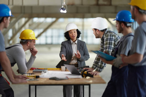 istock Female architect giving instructions to her workers at construction site. 2201634571