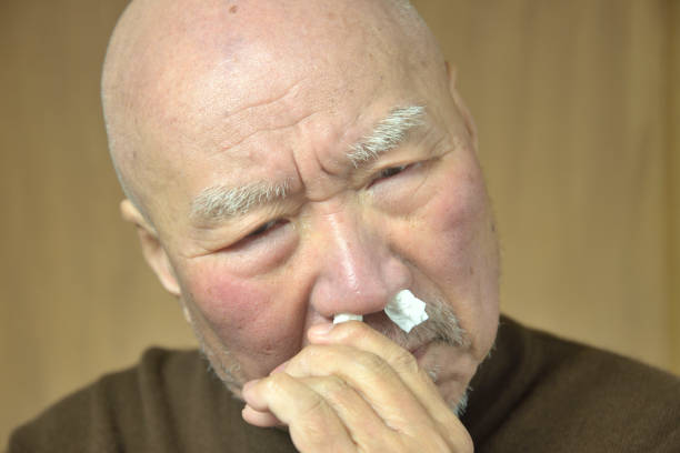 Old Japanese man suffering from runny nose