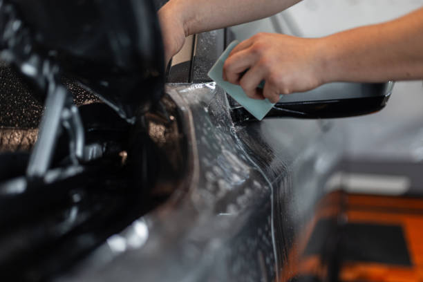 istock professional man does car detailing and covers it with protective film at a detailing service 2201637209