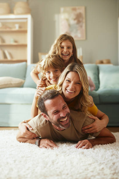 istock Happy parents and their kids making human pyramid at home. 2201637691