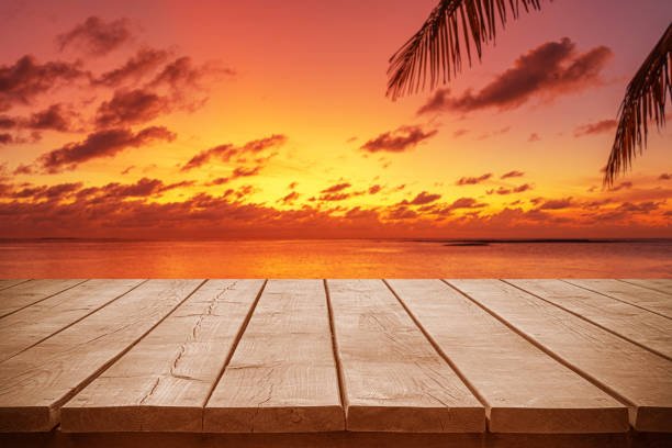 Empty wooden table top with tropical ocean sunset background