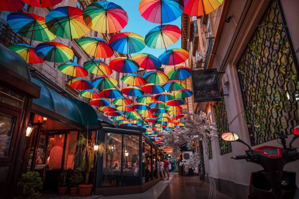 Bucharest, Romania – August 18, 2023: Colorful umbrellas hanging over a street in Bucharest, Romania on a sunny day